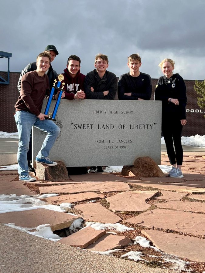 Lawson McVay, Ben Homan, Grace Weiteal, Ryan Gallagher, Ryan Sauter, Fox Everton, and Brylan Graber posed for a photo outside Liberty High School with their victory trophy.
